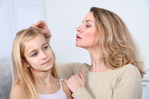 femme qui retire les poux de sa fille